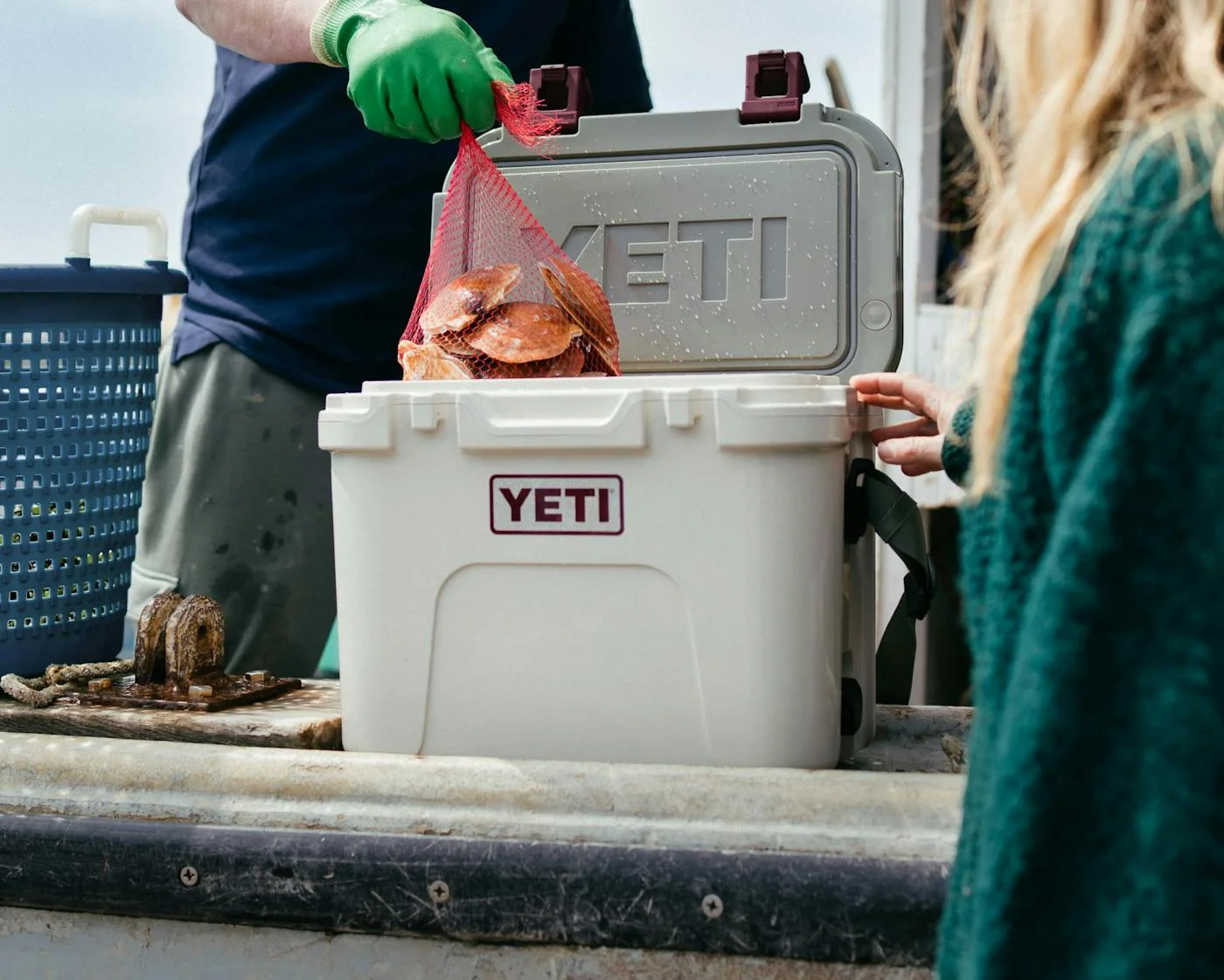 Fresh seafood being loaded into a YETI cooler at a dock