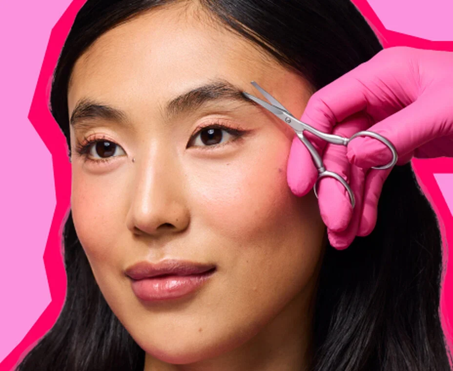 A Benefit brow expert shaping a customer’s eyebrows